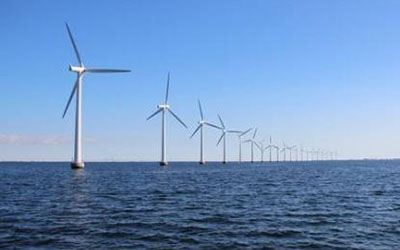 平靜的海面上佇立著一排風(fēng)力發(fā)電機(jī)，體現(xiàn)永磁材料在風(fēng)力發(fā)電領(lǐng)域的應(yīng)用